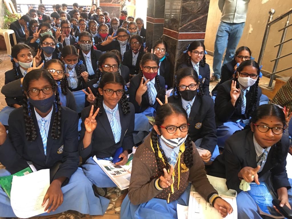 Children holding up peace signs and smiling